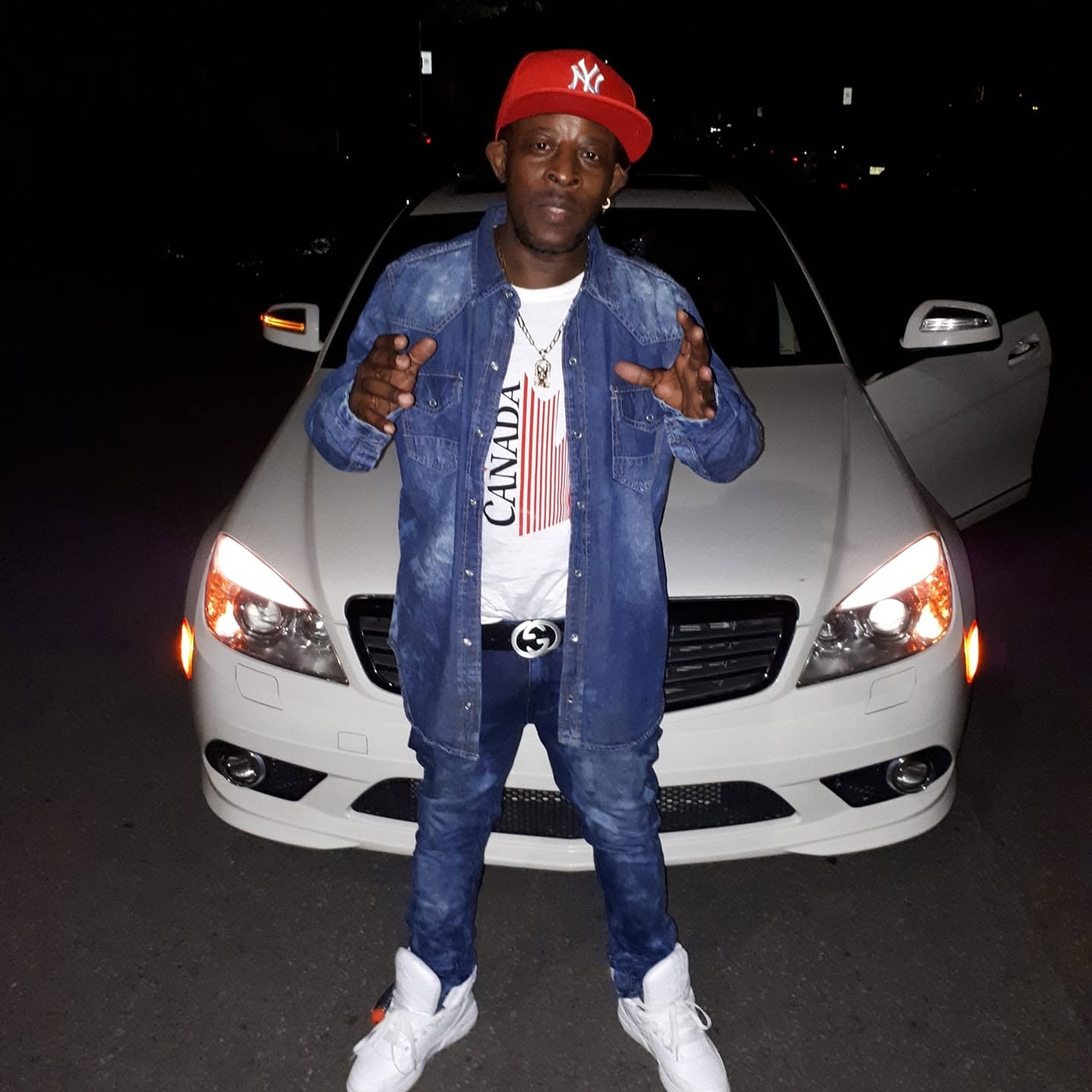 Likkle Wayne wearing red cap and denim outfit